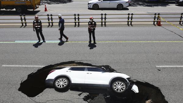 Driver and passenger injured as car is swallowed up by sinkhole